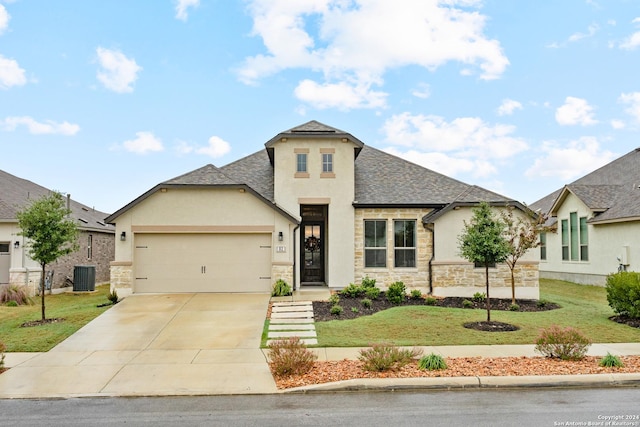 view of front of home featuring central AC, a front yard, and a garage