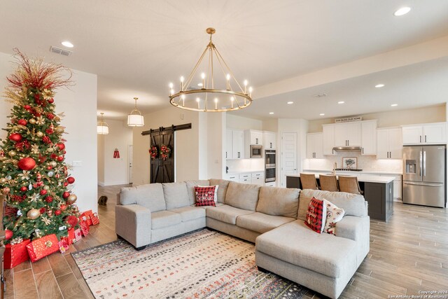 92 Simpatico, Boerne, TX 78006 - living room featuring a barn door, a chandelier, light wood-type flooring, and recessed lighting