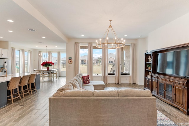 living room featuring light hardwood / wood-style flooring and a notable chandelier