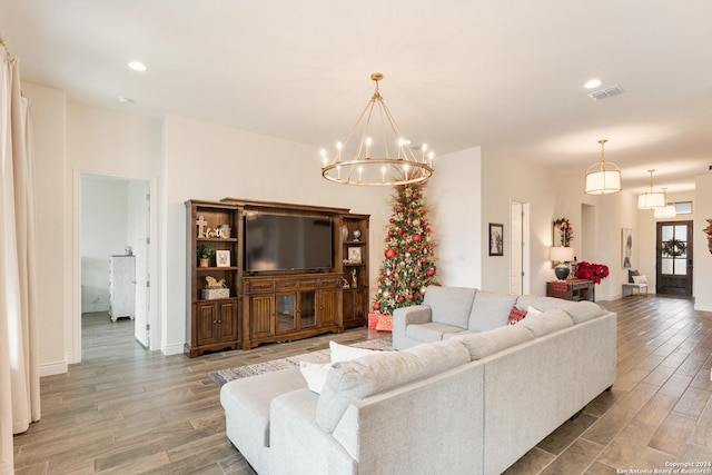 living room with hardwood / wood-style flooring and a notable chandelier