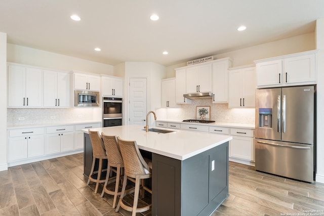 92 Simpatico, Boerne, TX 78006 - kitchen with stainless steel appliances, under cabinet range hood, white cabinetry, and recessed lighting