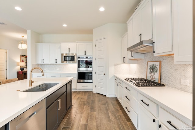 kitchen featuring white cabinets, decorative light fixtures, stainless steel appliances, and sink