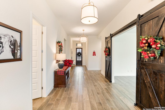 hallway featuring a barn door and light wood-type flooring