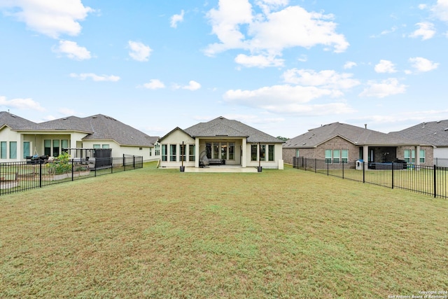 rear view of property with a lawn and a patio area