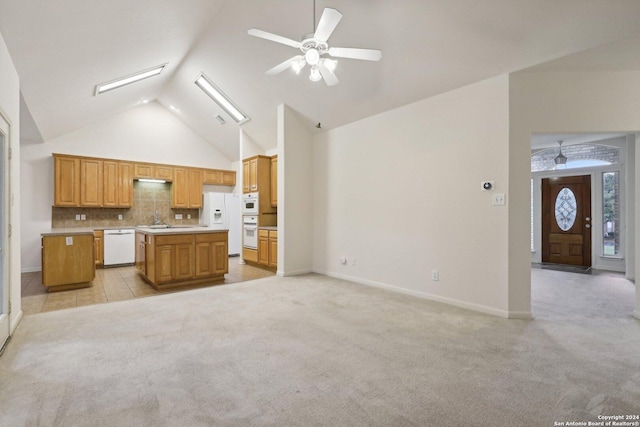 kitchen with decorative backsplash, white appliances, light colored carpet, vaulted ceiling, and a kitchen island