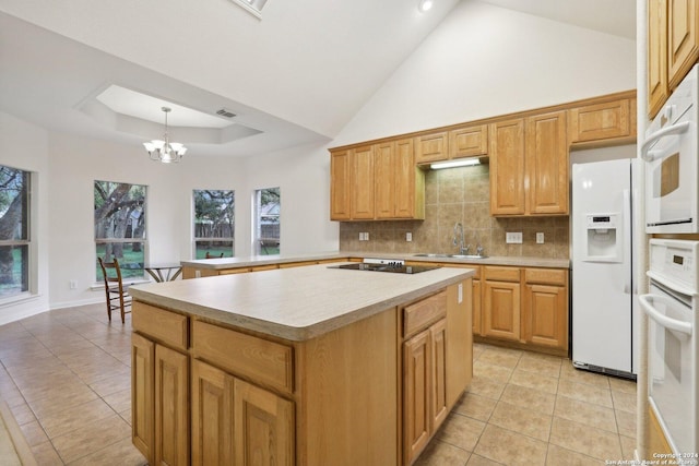 kitchen with a center island, sink, hanging light fixtures, a chandelier, and white appliances