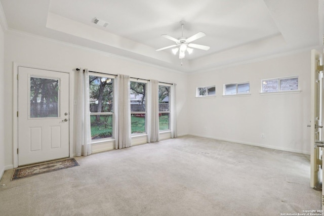 interior space with light carpet, a tray ceiling, ceiling fan, and crown molding