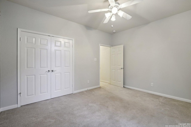 unfurnished bedroom with ceiling fan, a closet, and light colored carpet