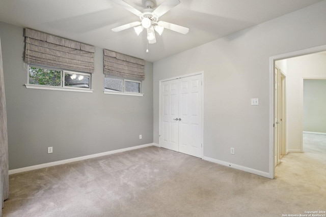 unfurnished bedroom with ceiling fan, a closet, and light colored carpet