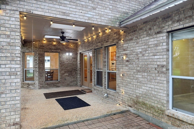 view of exterior entry with a patio area and ceiling fan