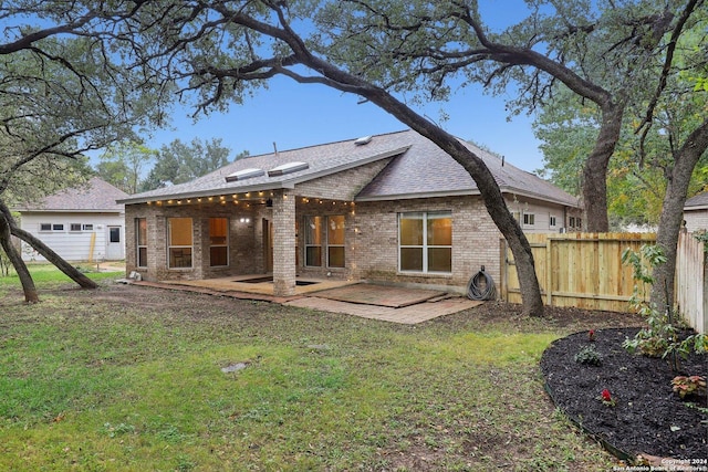 back of property featuring a yard and a patio