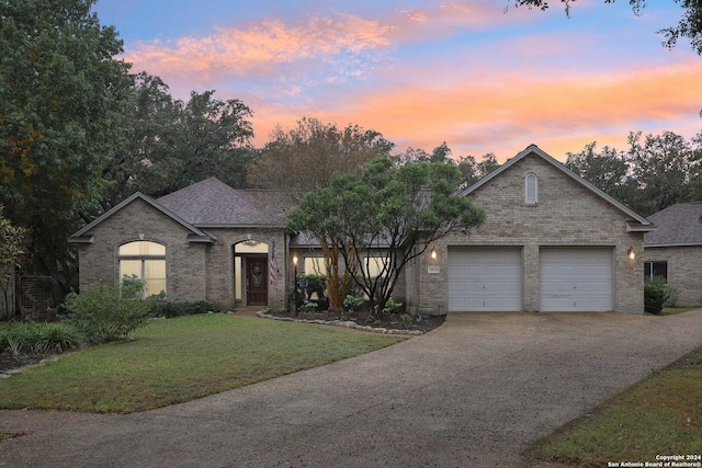 french country home featuring a lawn and a garage