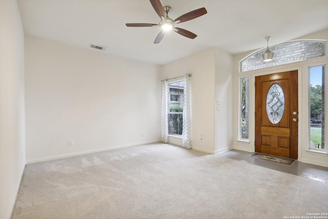 entrance foyer with ceiling fan and light carpet