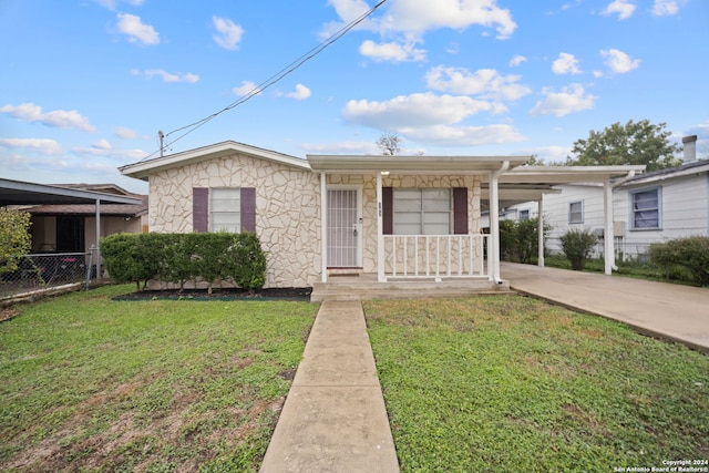 view of front of home with a front yard and a carport