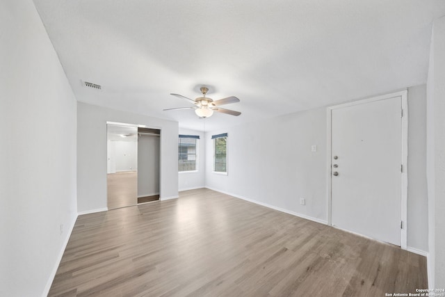 spare room with a textured ceiling, light hardwood / wood-style floors, and ceiling fan