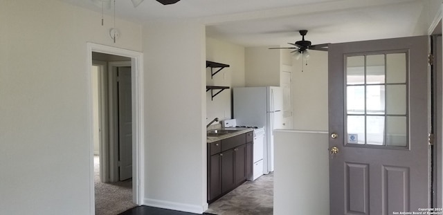 kitchen with ceiling fan, dark brown cabinets, light colored carpet, and white range