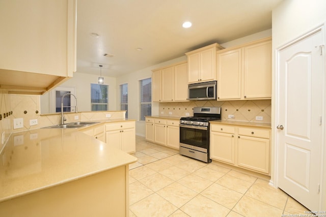 kitchen featuring sink, kitchen peninsula, pendant lighting, decorative backsplash, and appliances with stainless steel finishes