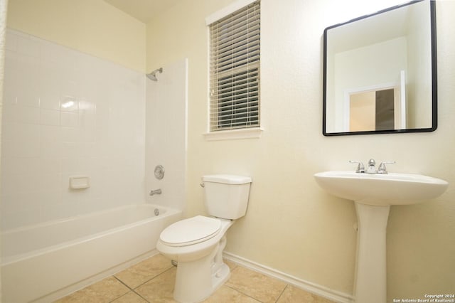 bathroom with tile patterned flooring, tiled shower / bath combo, and toilet