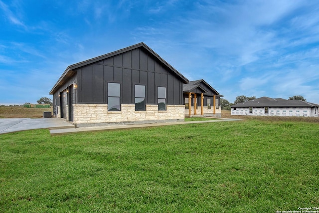 exterior space with central AC and a lawn