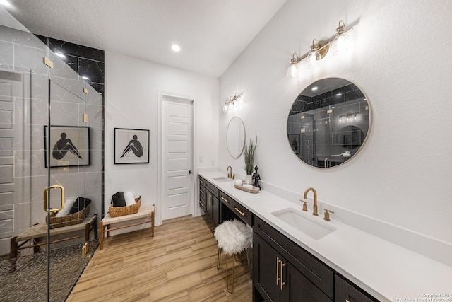 bathroom with hardwood / wood-style flooring, vanity, and walk in shower