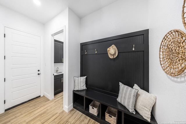 mudroom with light hardwood / wood-style floors and sink