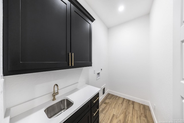 laundry area featuring sink, cabinets, electric dryer hookup, light hardwood / wood-style flooring, and hookup for a washing machine