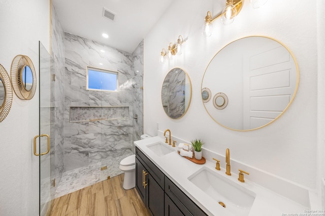 bathroom with hardwood / wood-style floors, vanity, toilet, and walk in shower