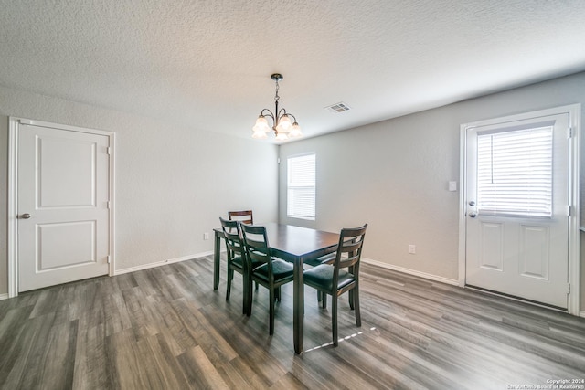 dining room featuring a chandelier, a textured ceiling, and dark hardwood / wood-style flooring