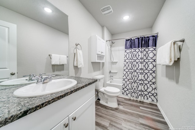 full bathroom with hardwood / wood-style flooring, vanity, toilet, and shower / tub combo