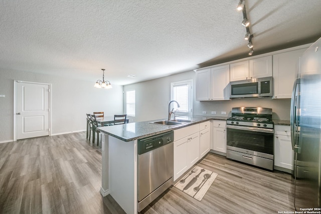 kitchen featuring sink, stainless steel appliances, kitchen peninsula, light hardwood / wood-style floors, and white cabinets