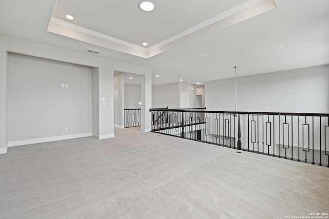 carpeted empty room with a tray ceiling and crown molding