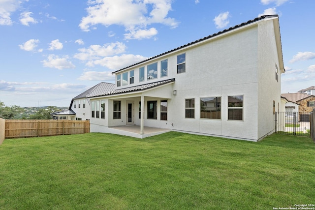 back of property featuring a lawn and a patio area