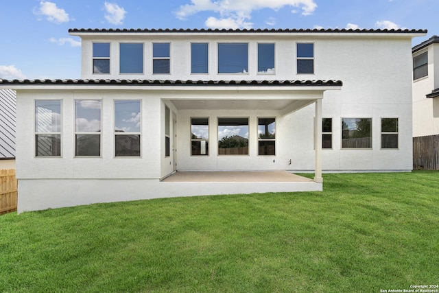 rear view of property featuring a lawn and a patio area