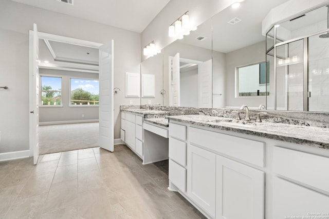 bathroom featuring a shower with door and vanity