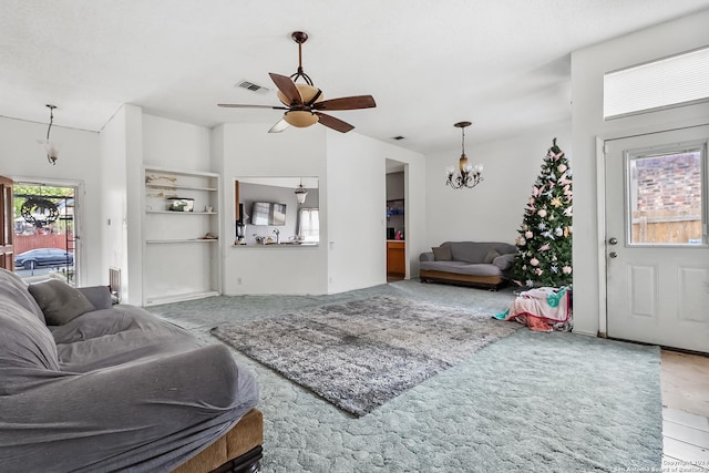 living room with ceiling fan with notable chandelier