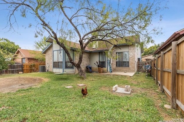 rear view of property with a yard, a patio, and central AC unit