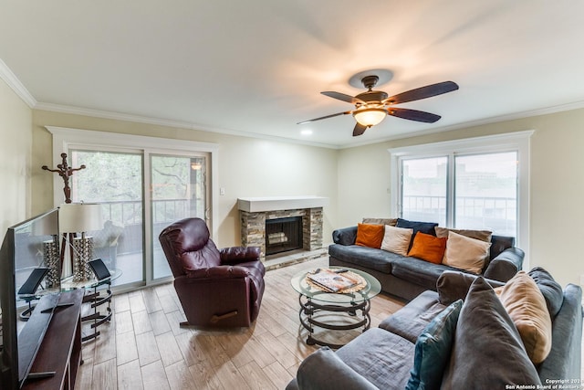 living room with ceiling fan, light wood-type flooring, a fireplace, and a wealth of natural light