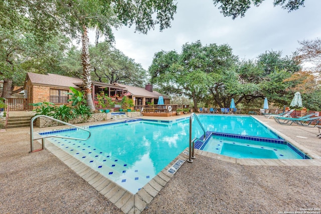 view of swimming pool featuring a patio area, a community hot tub, and a deck