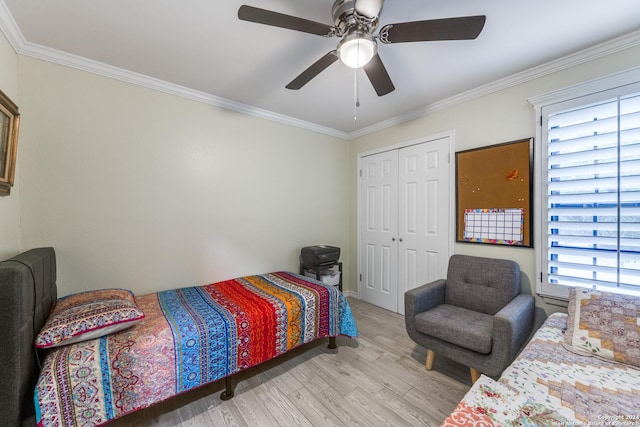 bedroom featuring a closet, light hardwood / wood-style floors, multiple windows, and ceiling fan