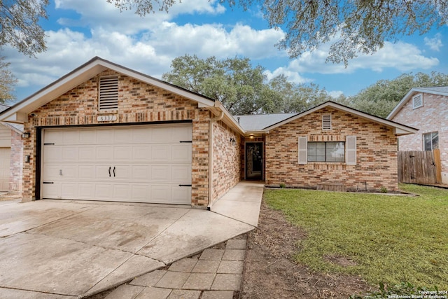 single story home with a garage and a front lawn