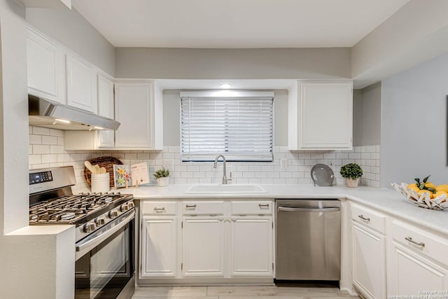 kitchen with decorative backsplash, sink, white cabinetry, and stainless steel appliances