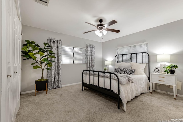 carpeted bedroom featuring ceiling fan and a closet