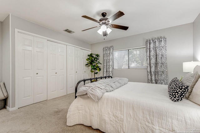 carpeted bedroom with ceiling fan and a closet