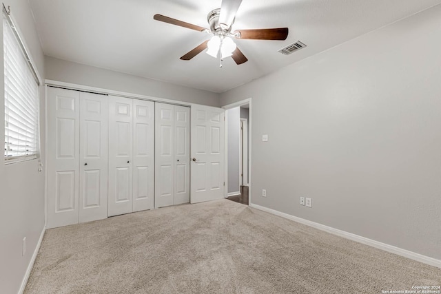 unfurnished bedroom featuring ceiling fan, a closet, and light colored carpet