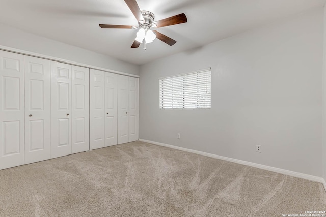 unfurnished bedroom featuring ceiling fan, a closet, and light carpet