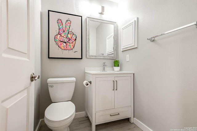 bathroom with hardwood / wood-style floors, vanity, and toilet