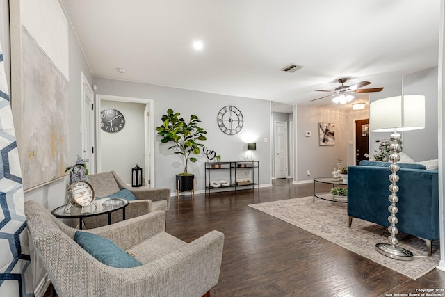 living room with ceiling fan and dark wood-type flooring