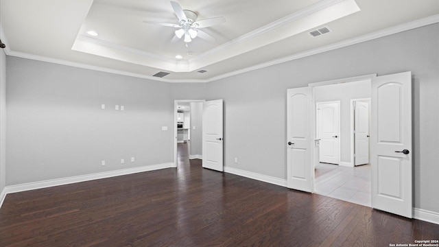 unfurnished bedroom with a raised ceiling, ceiling fan, hardwood / wood-style floors, and ornamental molding