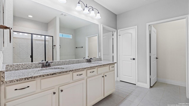 bathroom with tile patterned floors, a shower with door, and vanity