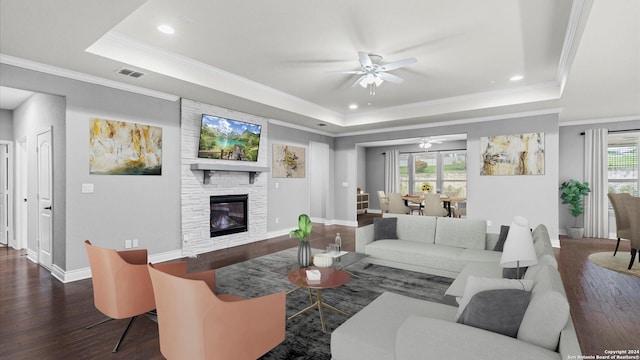 living room featuring plenty of natural light, dark hardwood / wood-style flooring, and a tray ceiling